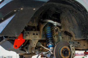 Closeup view of a single heavy duty rated towing point, upper control arm, strut and coil spring fitted to the front end of a NP300 Nissan Navara